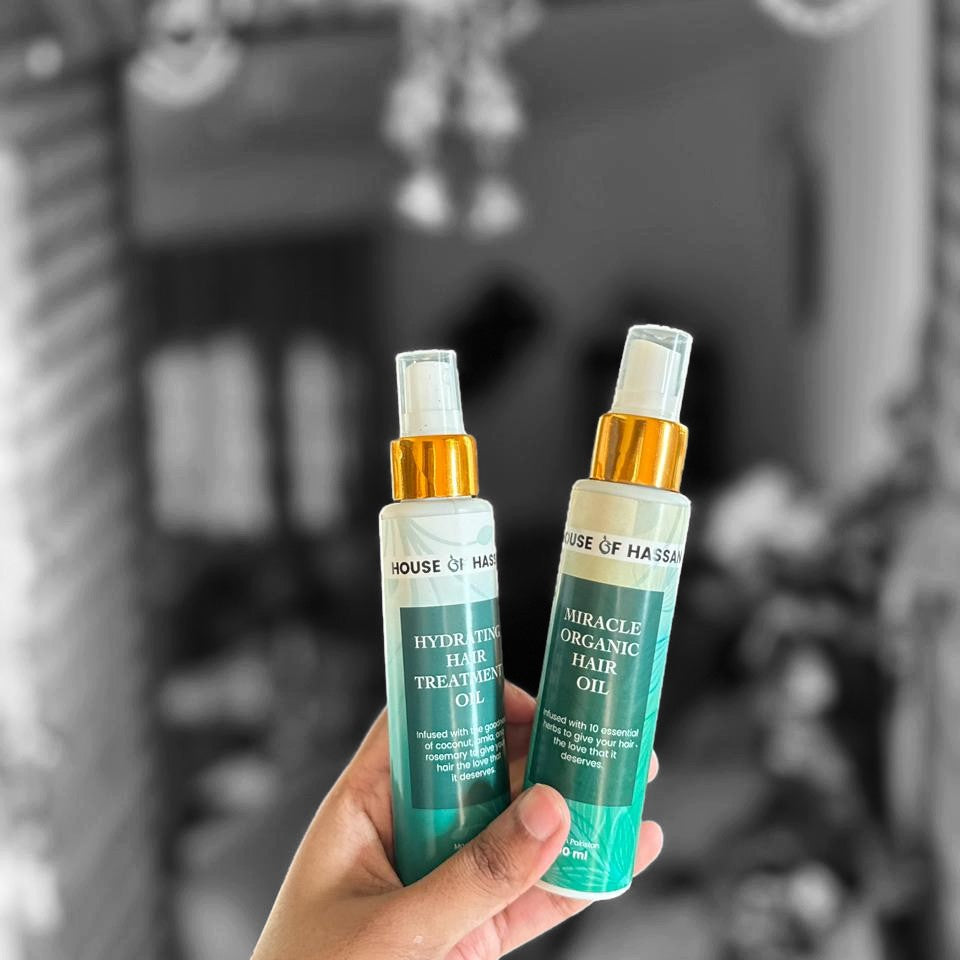 Two bottles of 'House of Harlow' hair products held in front of a mirror.